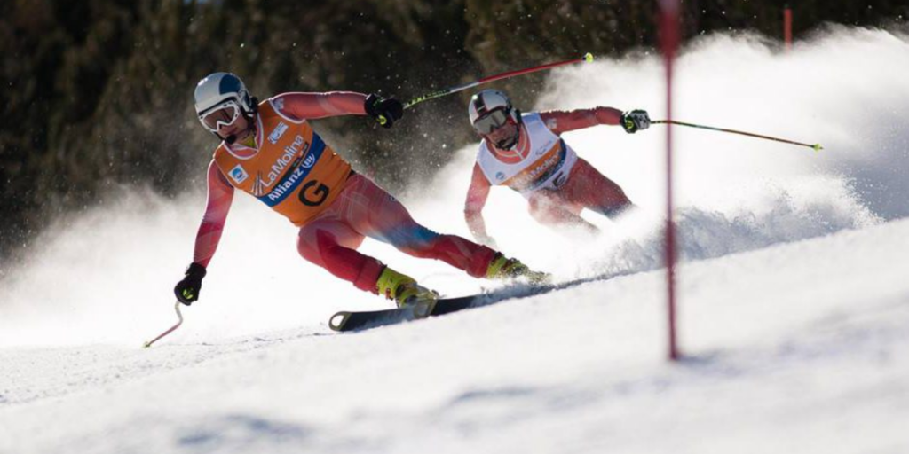 Esquiador amb el seu guia baixant una baixada en una competició